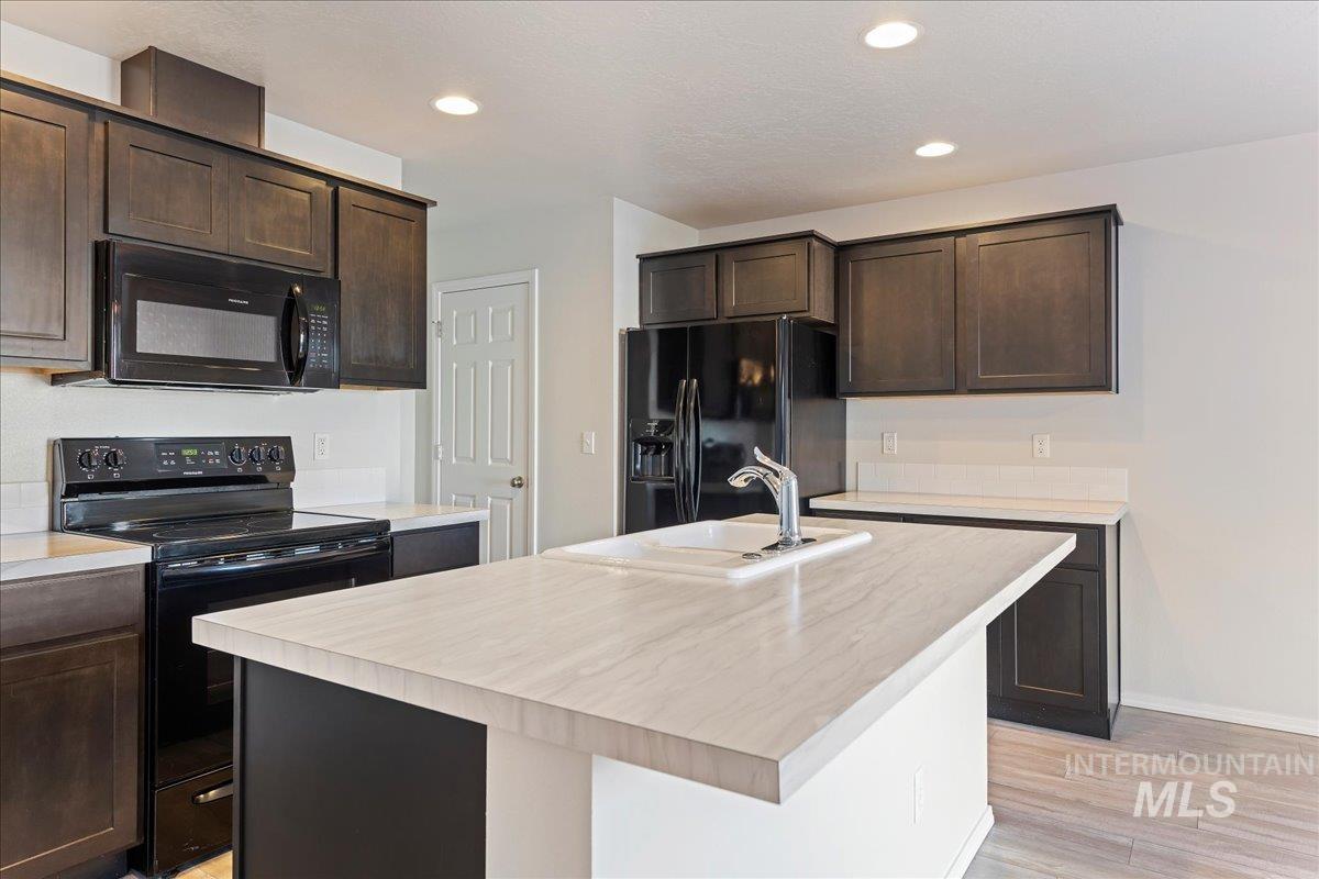 926 West Woodpine Street Meridian, ID 83646 - Photo 6 of 32 Kitchen with black appliances, light countertops, and recessed lighting
