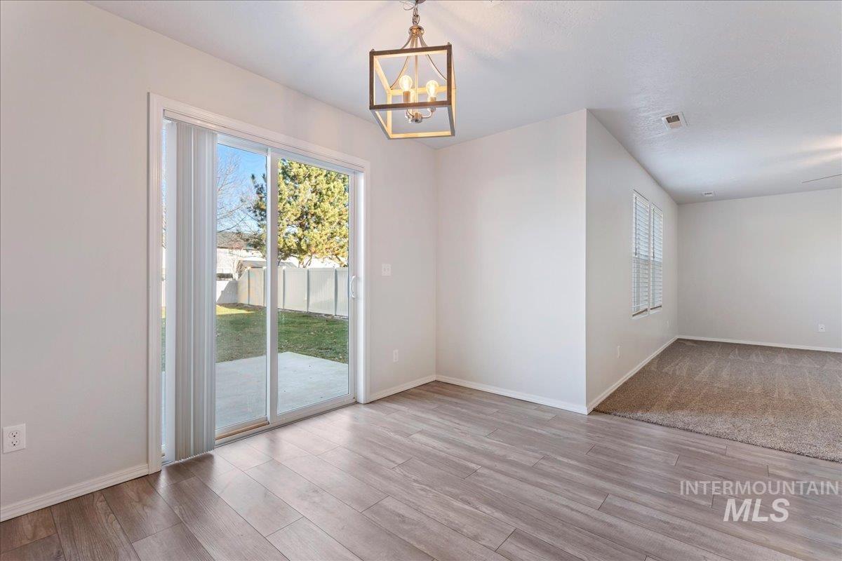 926 West Woodpine Street Meridian, ID 83646 - Photo 9 of 32 Unfurnished dining area with light wood finished floors and a chandelier