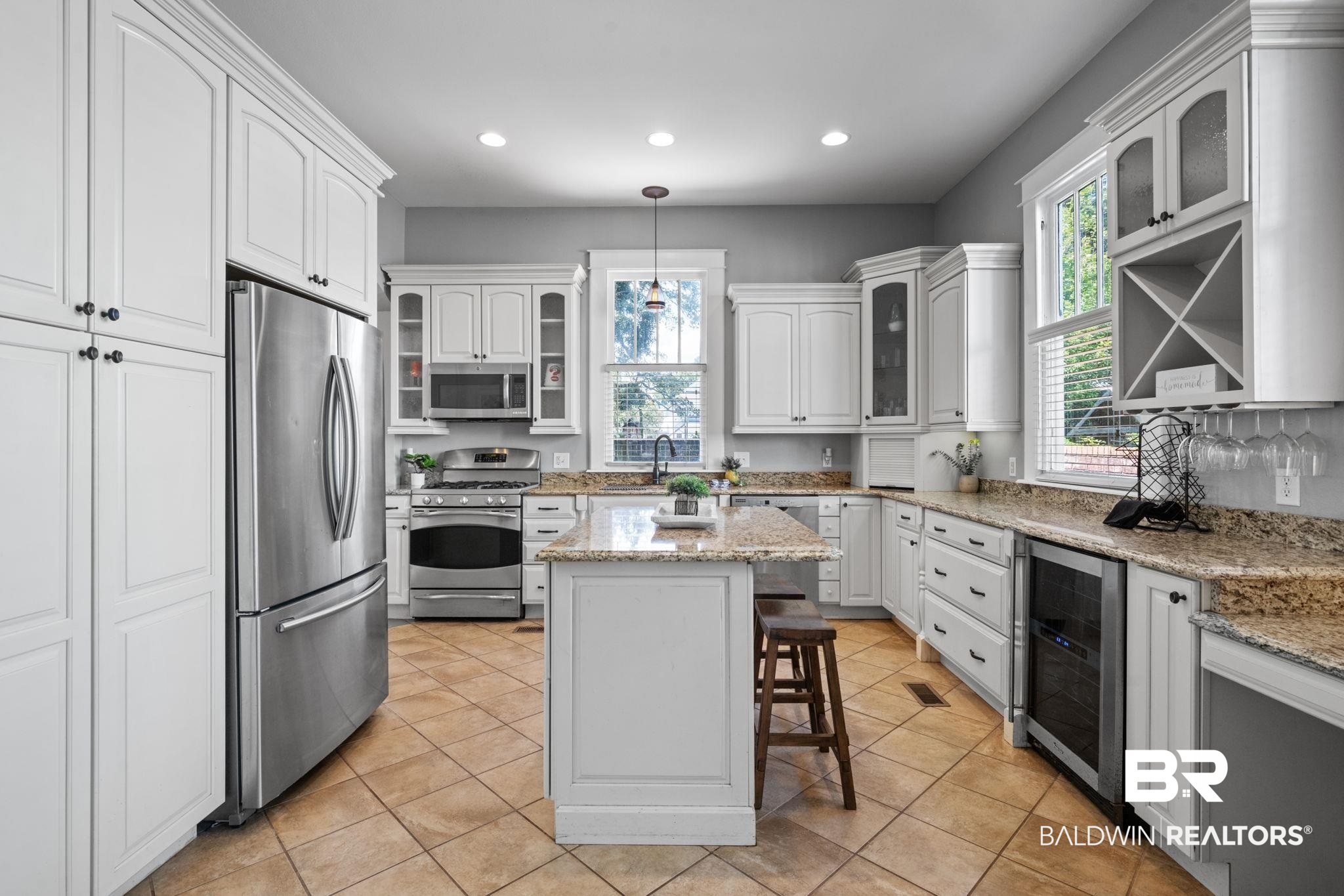 10 South Monterey Street Mobile, AL 36604 - Photo 13 of 45 Kitchen with glass insert cabinets, appliances with stainless steel finishes, light stone counters, white cabinets, and wine cooler