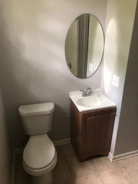 a bathroom with a toilet mirror and sink