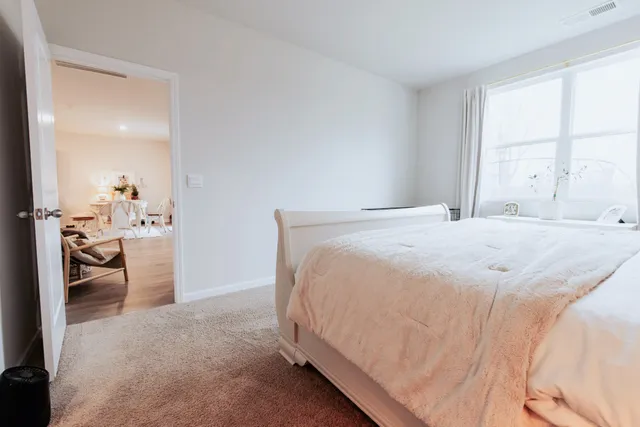 a spacious bedroom with a bed and a window