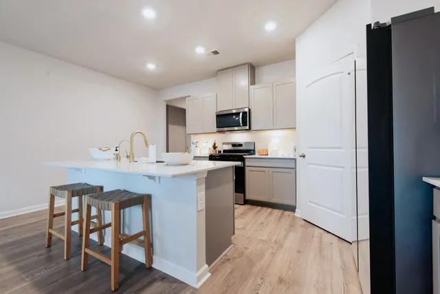 a kitchen with kitchen island granite countertop a sink stove and refrigerator