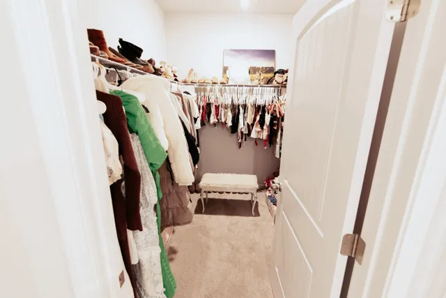 a view of walk in closet with clothes and shoes