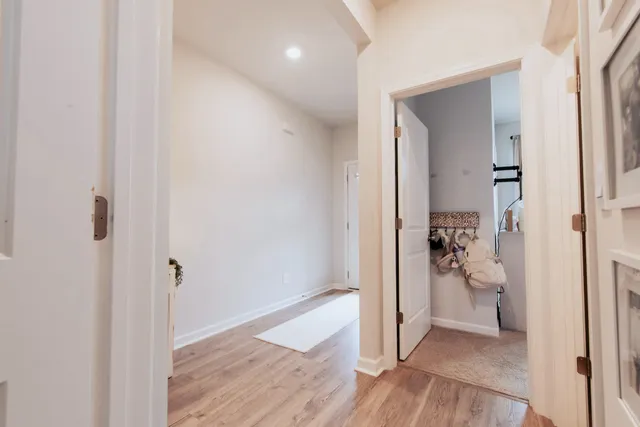 a view of a hallway with wooden floor and a livingroom