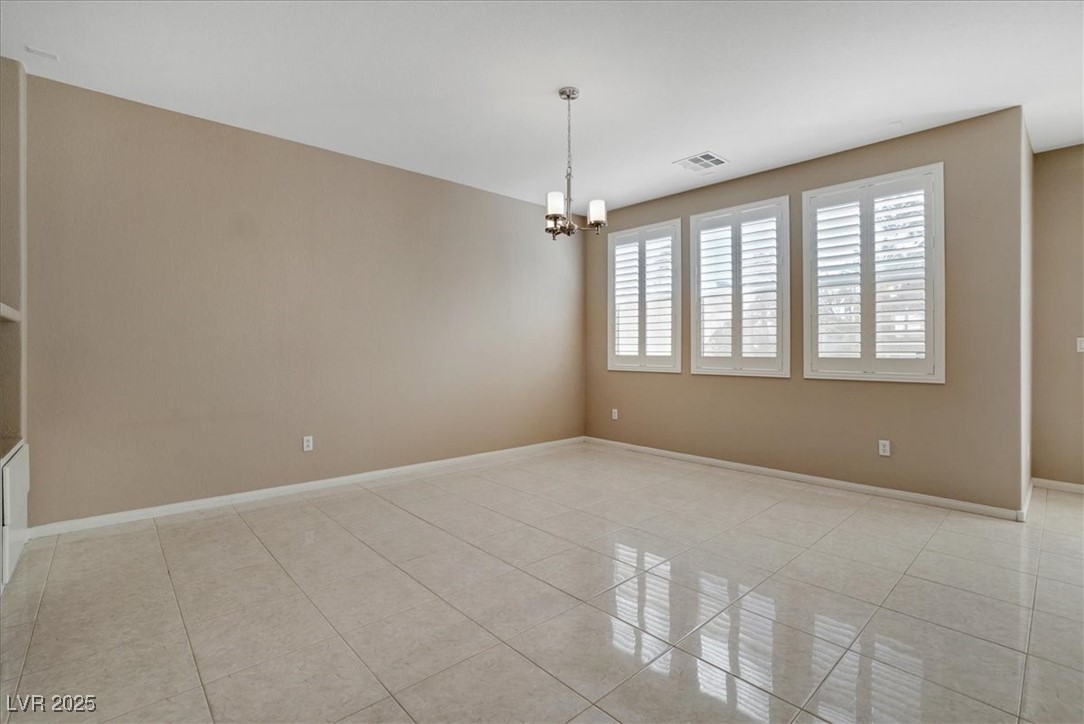 319 Fox Lake Avenue Las Vegas, NV 89148 - Photo 19 of 39 Spare room with light tile patterned floors and a chandelier