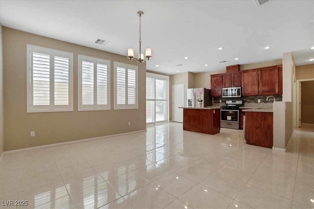 319 Fox Lake Avenue Las Vegas, NV 89148 - Photo 38 of 39 Kitchen with open floor plan, pendant lighting, a kitchen island, appliances with stainless steel finishes, and a chandelier