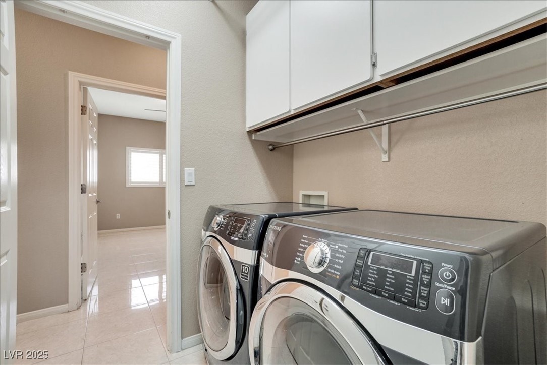 319 Fox Lake Avenue Las Vegas, NV 89148 - Photo 28 of 39 Laundry area with cabinet space, light tile patterned floors, and washing machine and dryer