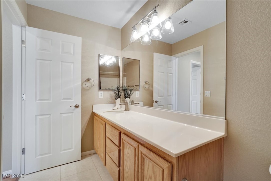 319 Fox Lake Avenue Las Vegas, NV 89148 - Photo 34 of 39 Bathroom with vanity, light tile patterned flooring, and a textured wall