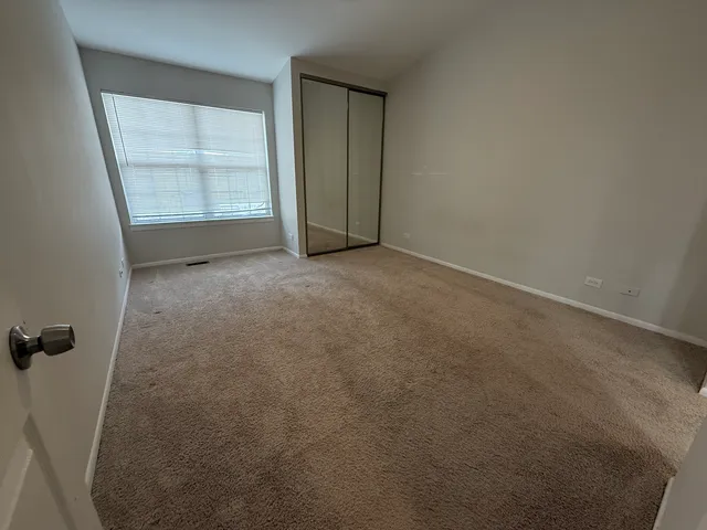an empty room with windows and closet