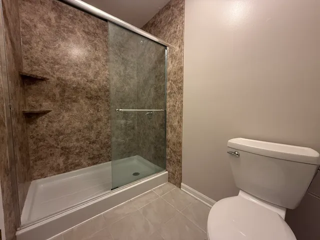 a white toilet sitting next to a bath tub