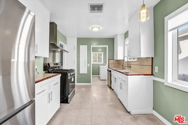 a large kitchen with a sink and cabinets