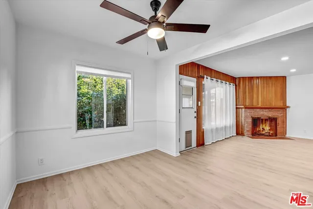 an empty room with fireplace and windows