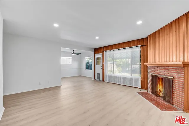 a view of an empty room with a fireplace and a window