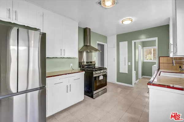 a kitchen with stainless steel appliances granite countertop a refrigerator and a stove