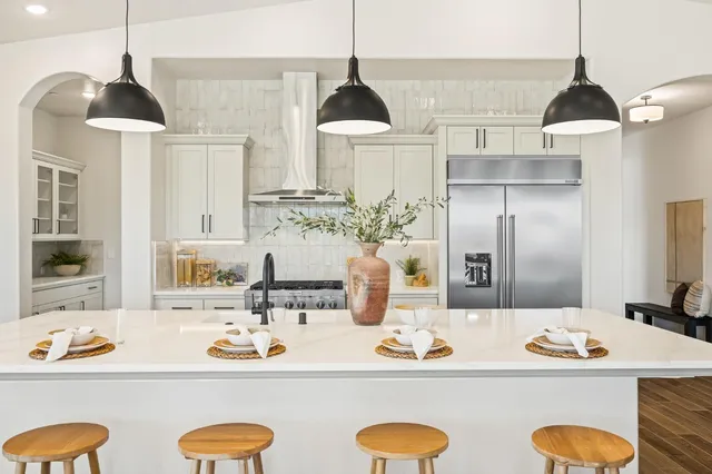a kitchen with stainless steel appliances granite countertop a sink stove and refrigerator