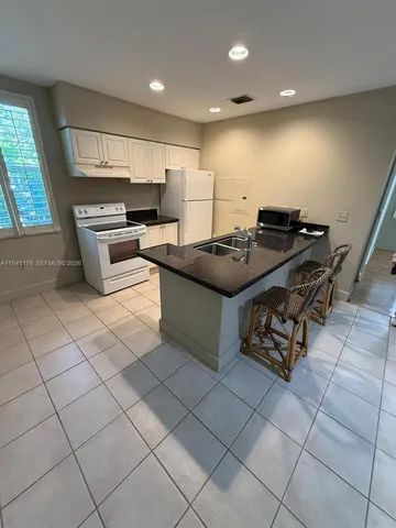 a bathroom with a granite countertop sink a mirror and a bathtub
