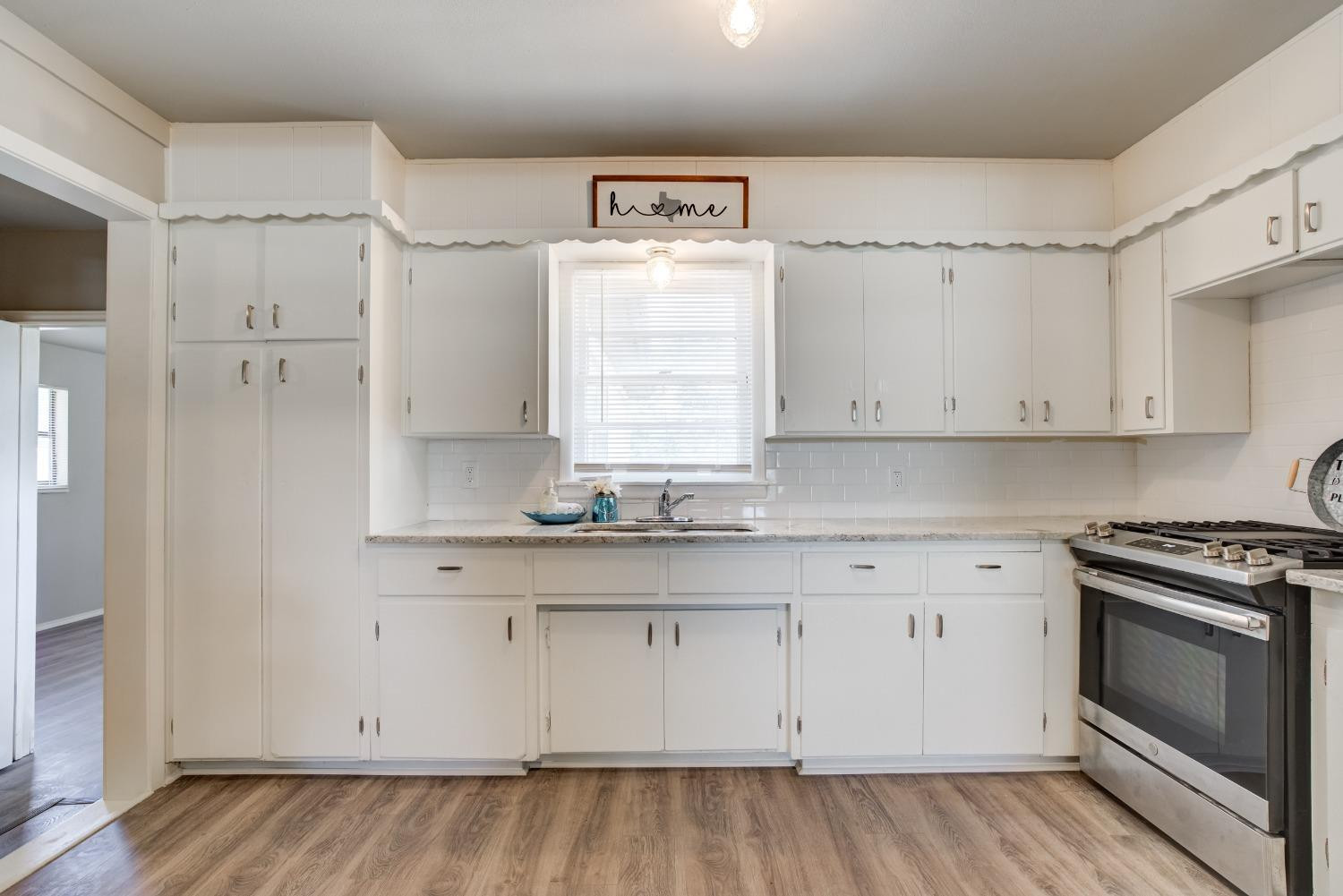 4629 Elgin Avenue Lubbock, TX 79413 - Photo 12 of 34 a kitchen with white cabinets and white appliances