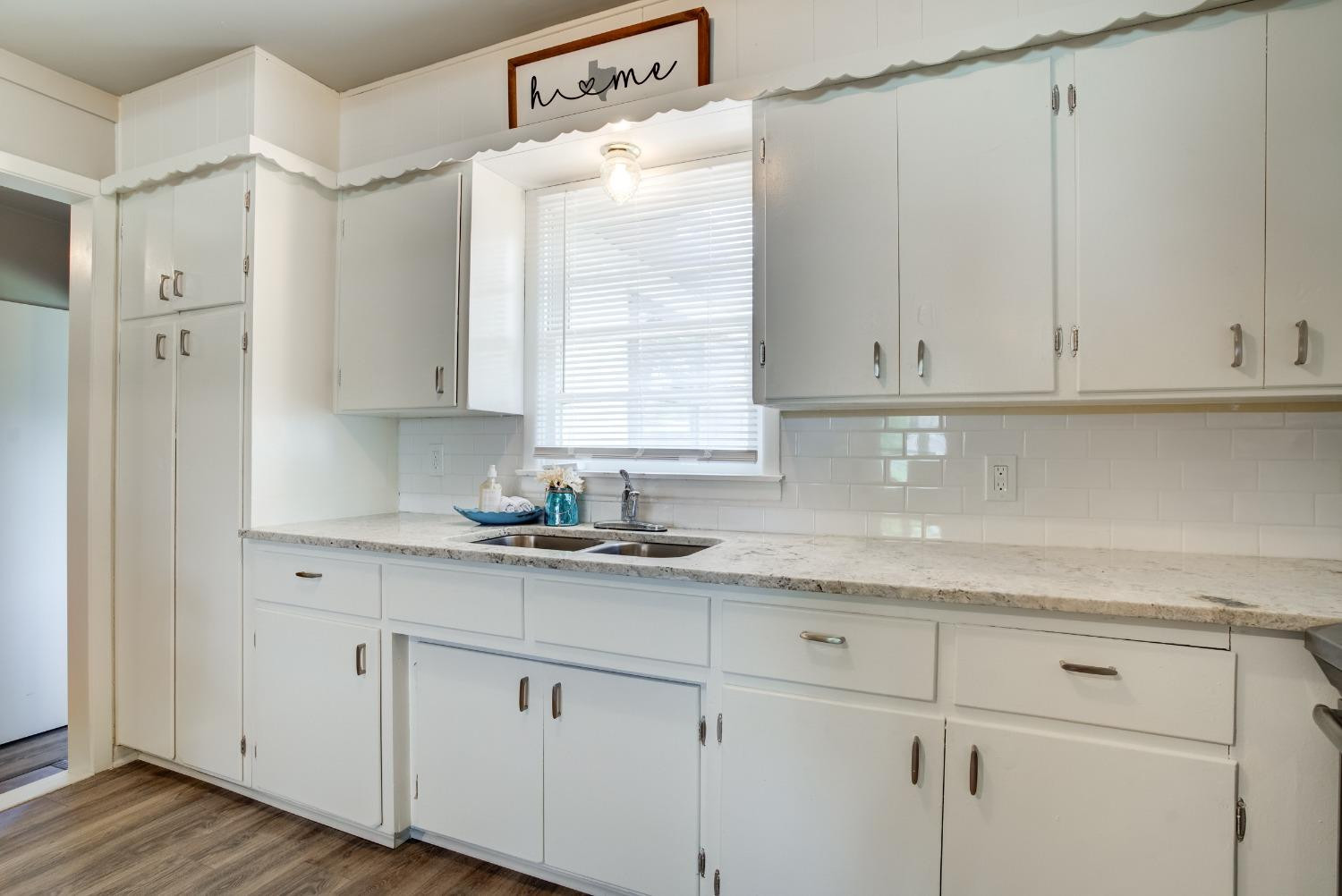 4629 Elgin Avenue Lubbock, TX 79413 - Photo 15 of 34 a kitchen with granite countertop white cabinets and white appliances