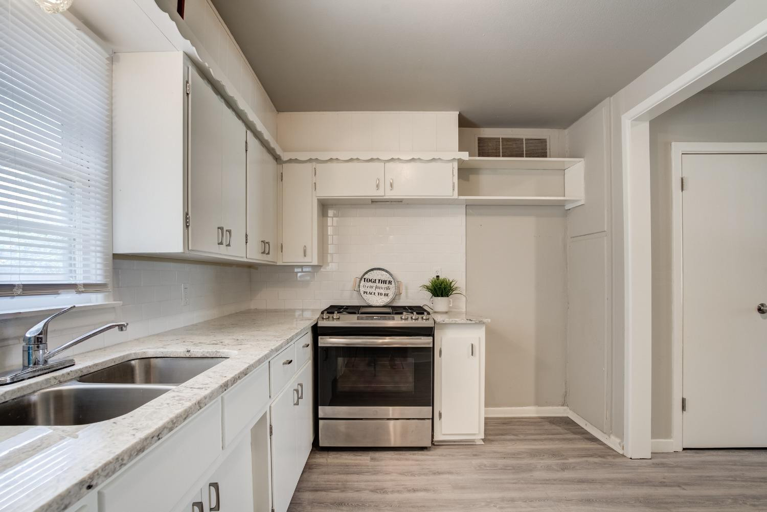 4629 Elgin Avenue Lubbock, TX 79413 - Photo 19 of 34 a kitchen with cabinets a oven and a sink