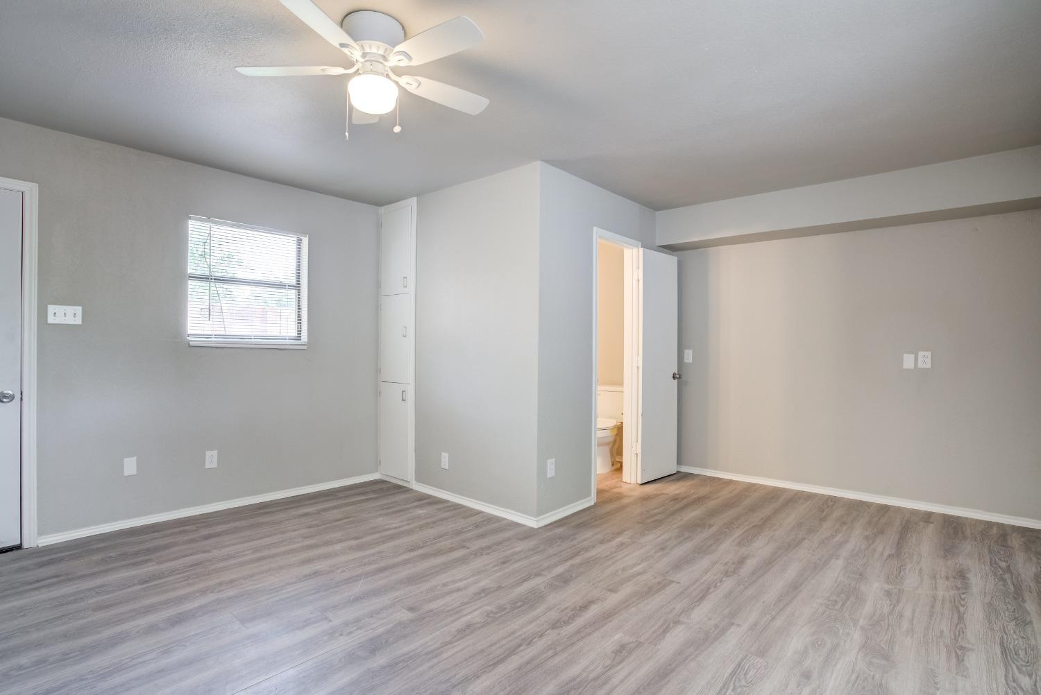 4629 Elgin Avenue Lubbock, TX 79413 - Photo 23 of 34 an empty room with wooden floor and windows