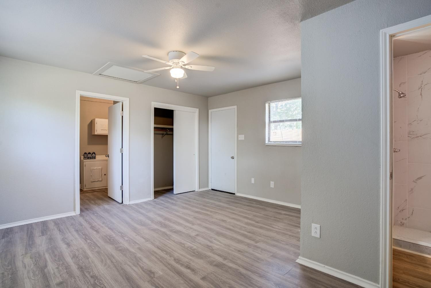 4629 Elgin Avenue Lubbock, TX 79413 - Photo 24 of 34 a view of an empty room with wooden floor and a window
