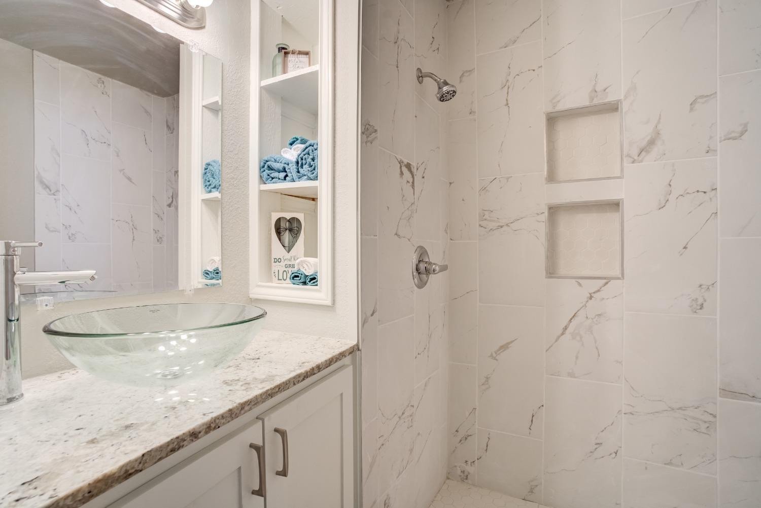 4629 Elgin Avenue Lubbock, TX 79413 - Photo 27 of 34 a bathroom with a granite countertop shower sink and mirror