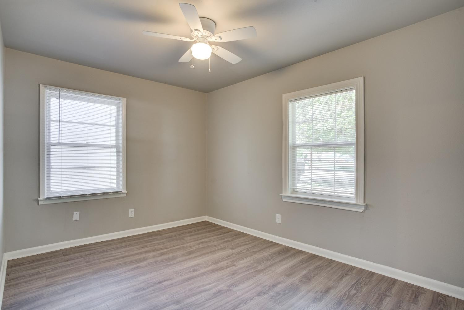 4629 Elgin Avenue Lubbock, TX 79413 - Photo 28 of 34 an empty room with wooden floor ceiling fan and windows
