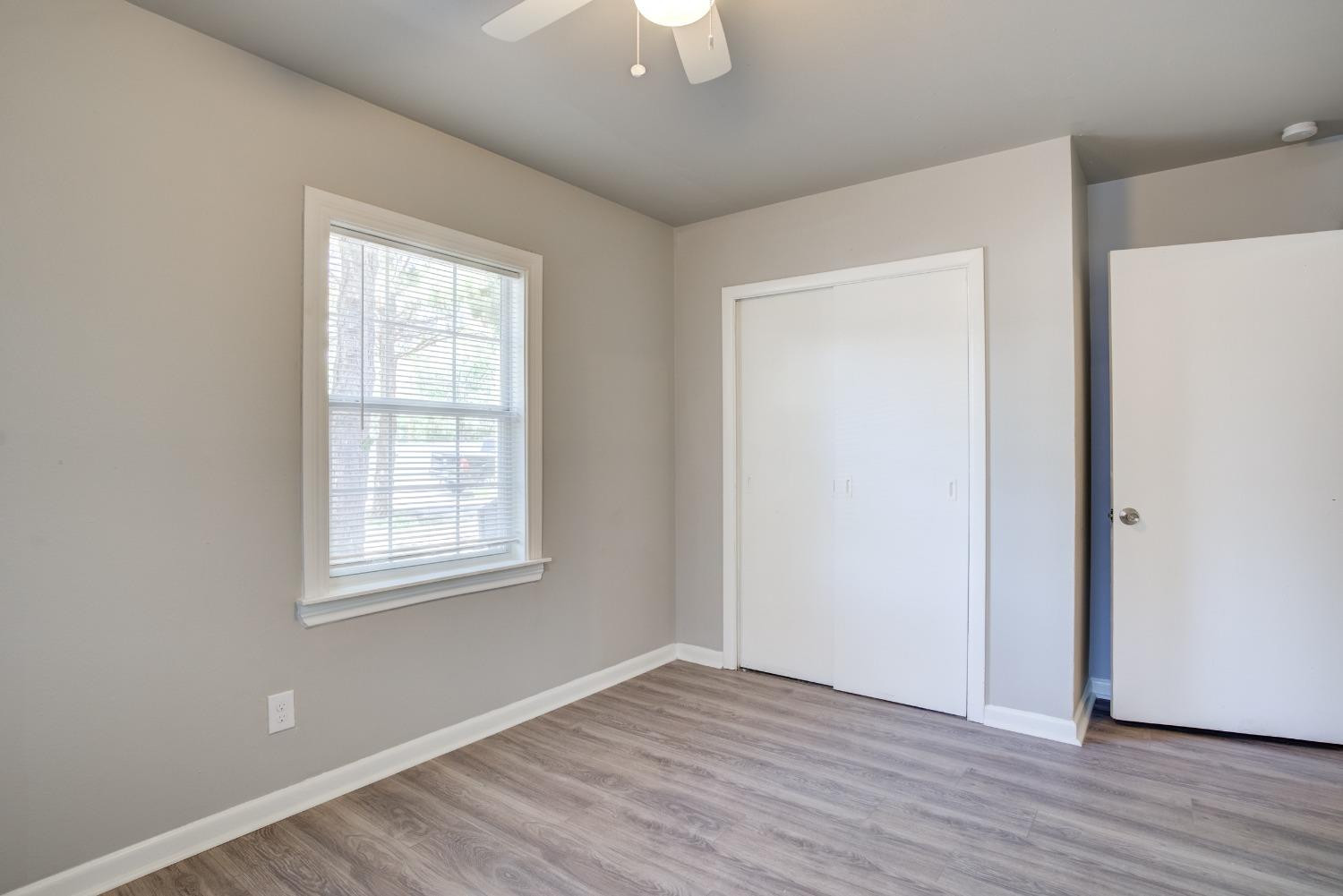 4629 Elgin Avenue Lubbock, TX 79413 - Photo 29 of 34 an empty room with wooden floor and windows