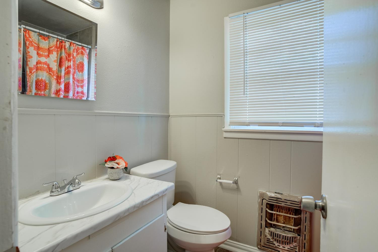 4629 Elgin Avenue Lubbock, TX 79413 - Photo 32 of 34 a bathroom with a sink a toilet and a mirror