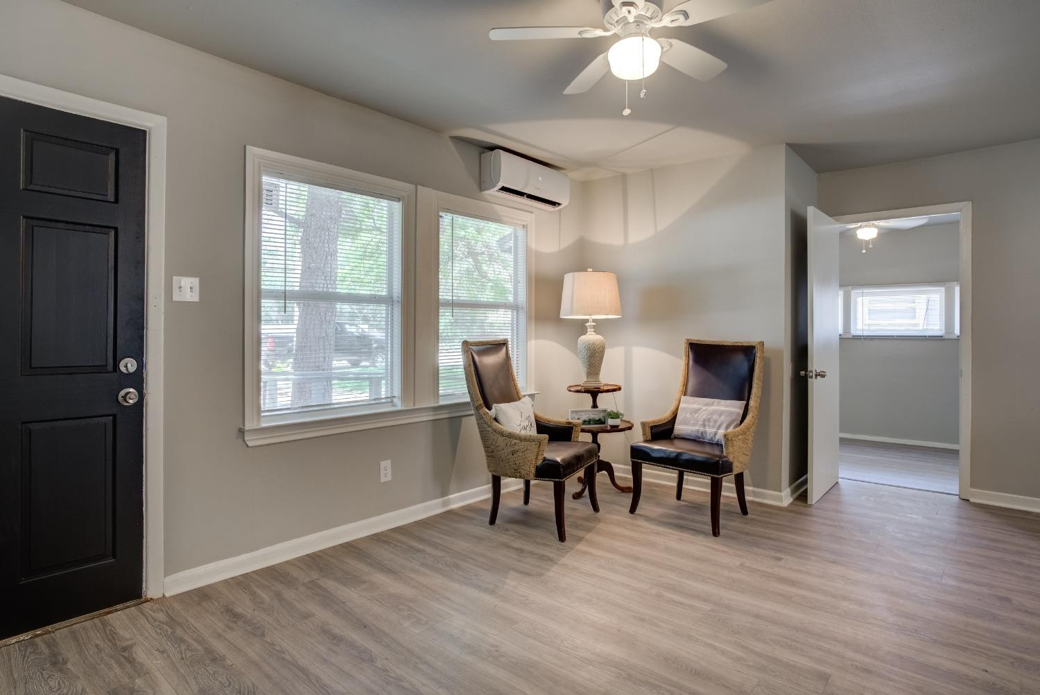 4629 Elgin Avenue Lubbock, TX 79413 - Photo 4 of 34 a dining room with wooden floor a chandelier a glass table and chairs