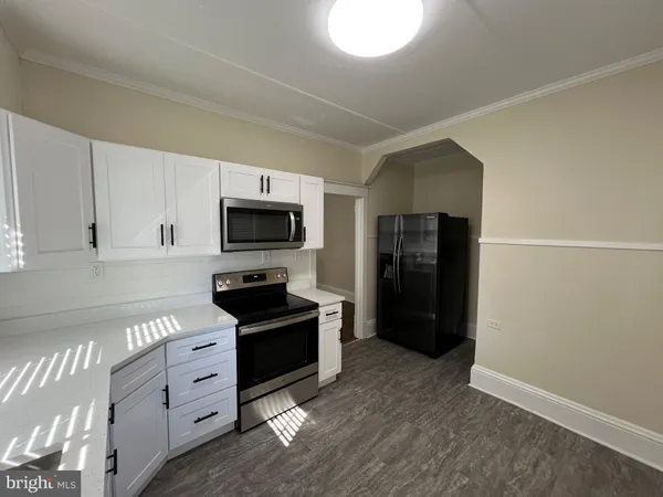 a kitchen with granite countertop a refrigerator and a stove top oven