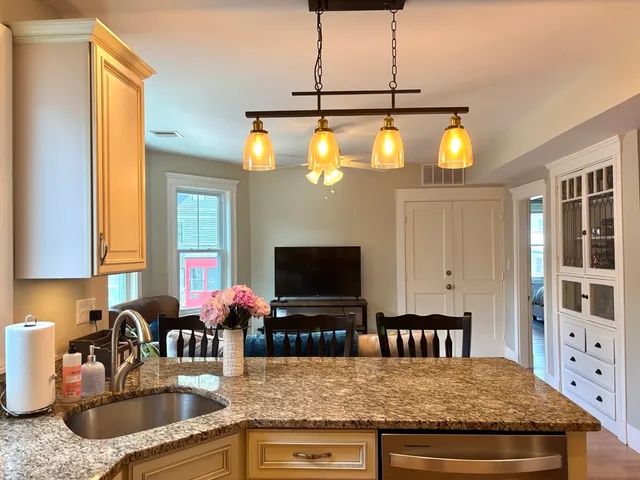 a kitchen with a stove a sink and a wooden cabinets
