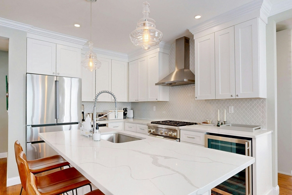 96 Floral Street, Unit 1 Newton, MA 02461 - Photo 13 of 42 a kitchen with stainless steel appliances granite countertop a sink refrigerator and cabinets