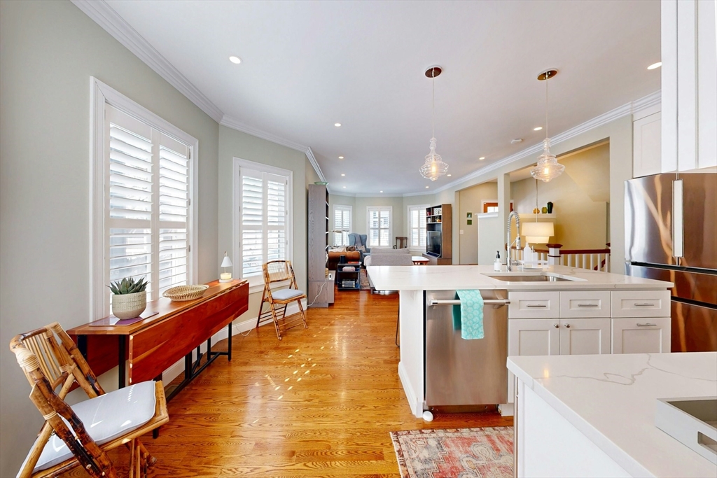96 Floral Street, Unit 1 Newton, MA 02461 - Photo 15 of 42 a large living room with stainless steel appliances kitchen island granite countertop furniture and a kitchen view