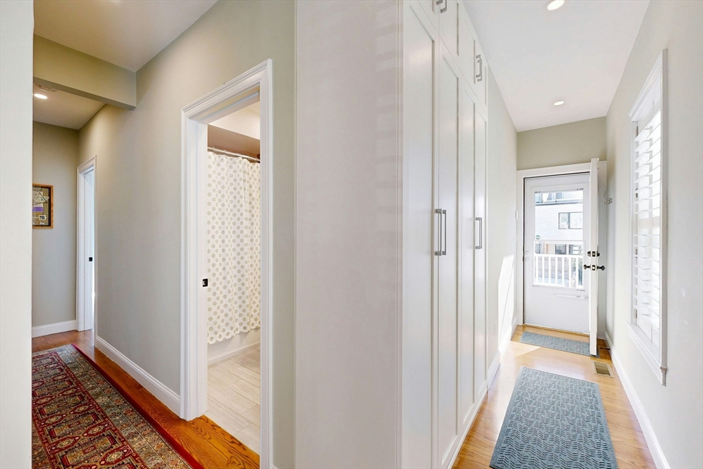 96 Floral Street, Unit 1 Newton, MA 02461 - Photo 17 of 42 a view of a hallway with a livingroom and a hall with wooden floor