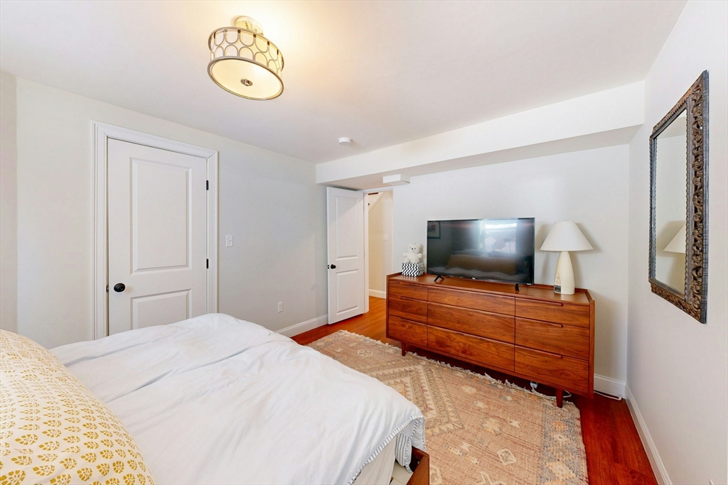 96 Floral Street, Unit 1 Newton, MA 02461 - Photo 37 of 42 a bedroom with a bed and flat screen tv