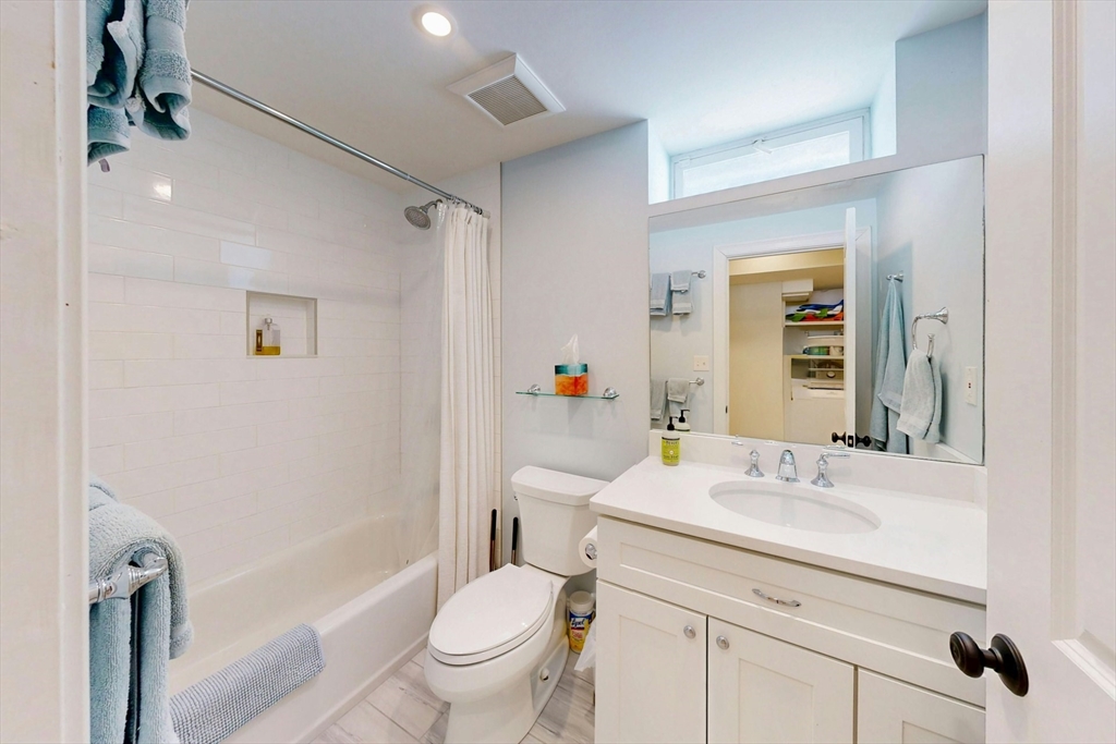 96 Floral Street, Unit 1 Newton, MA 02461 - Photo 38 of 42 a bathroom with a sink a toilet and shower a mirror