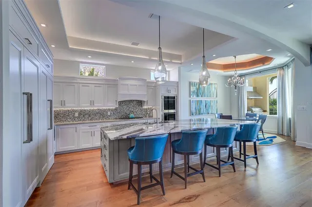 a kitchen with stainless steel appliances granite countertop a stove and a large window