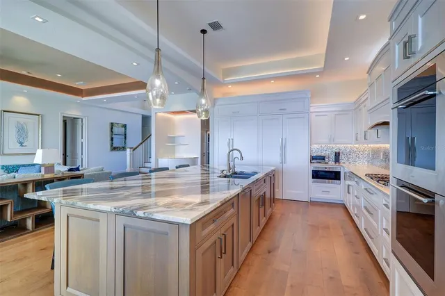 a bedroom with a bed and dresser with wooden floor