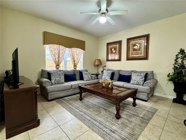 a living room with furniture kitchen view and a chandelier