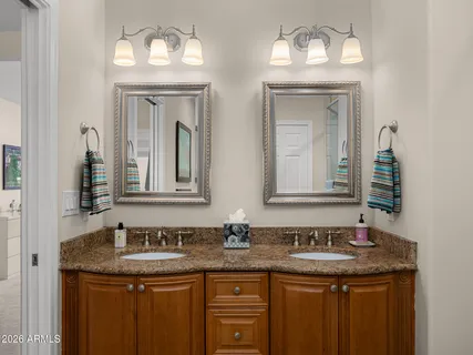 a bedroom with a bed chandelier painting on wall and a desk