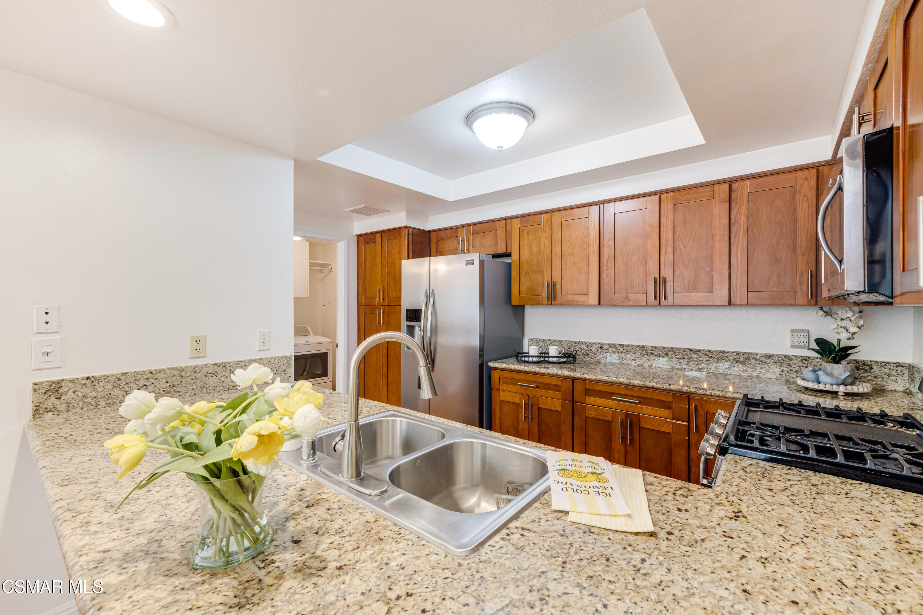 4240 Lost Hills Road, Unit 1902 Calabasas, CA 91301 - Photo 10 of 37 a kitchen with stainless steel appliances granite countertop a sink a stove and a wooden cabinets