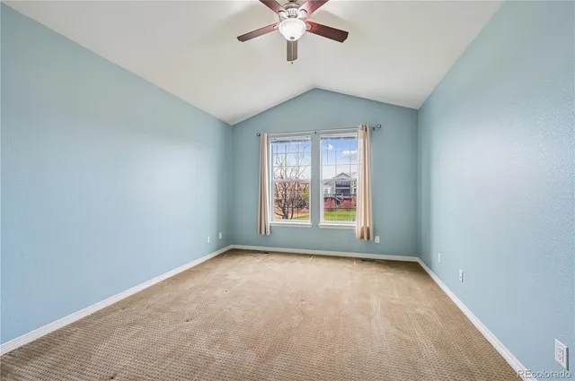 an empty room with a window and a ceiling fan
