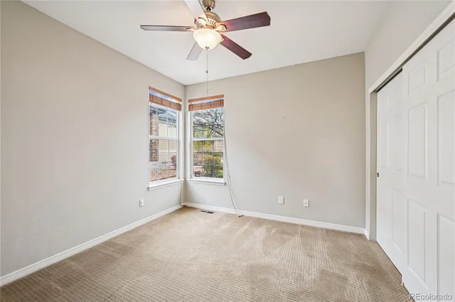 an empty room with a window and a fan