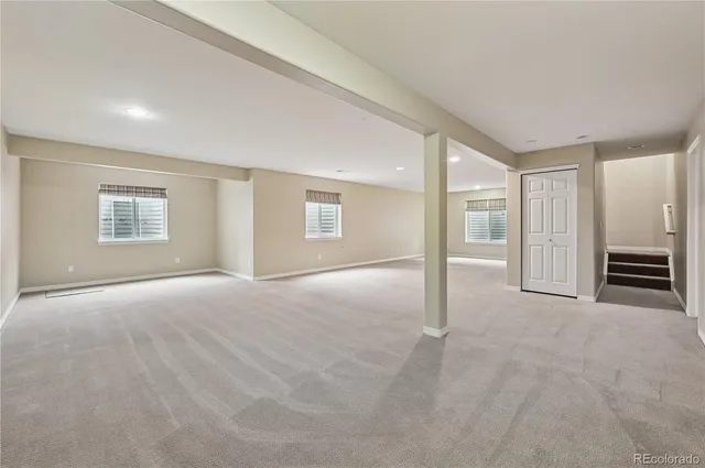 a view of an empty room with a fireplace and a window