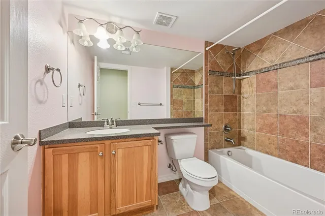 a bathroom with a granite countertop sink a toilet and bathtub