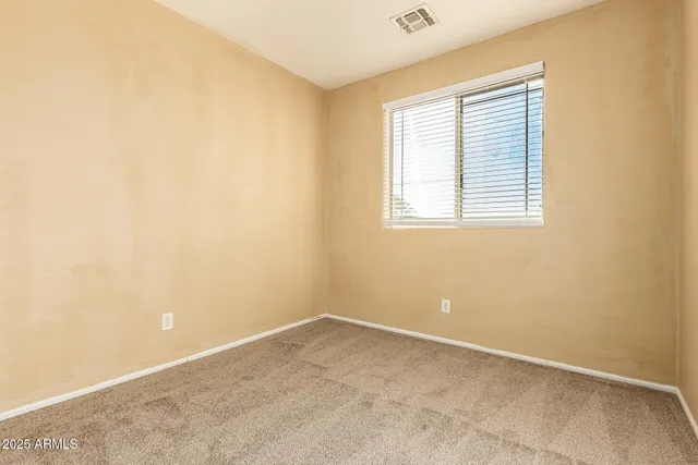 an empty room with a bathroom and a ceiling fan