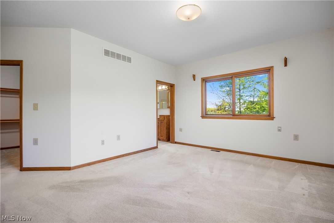 51488 Peck Wadsworth Road Wellington, OH 44090 - Photo 31 of 50 Spacious room featuring light-toned carpeting, white wall finishes, and wood-trim accents
