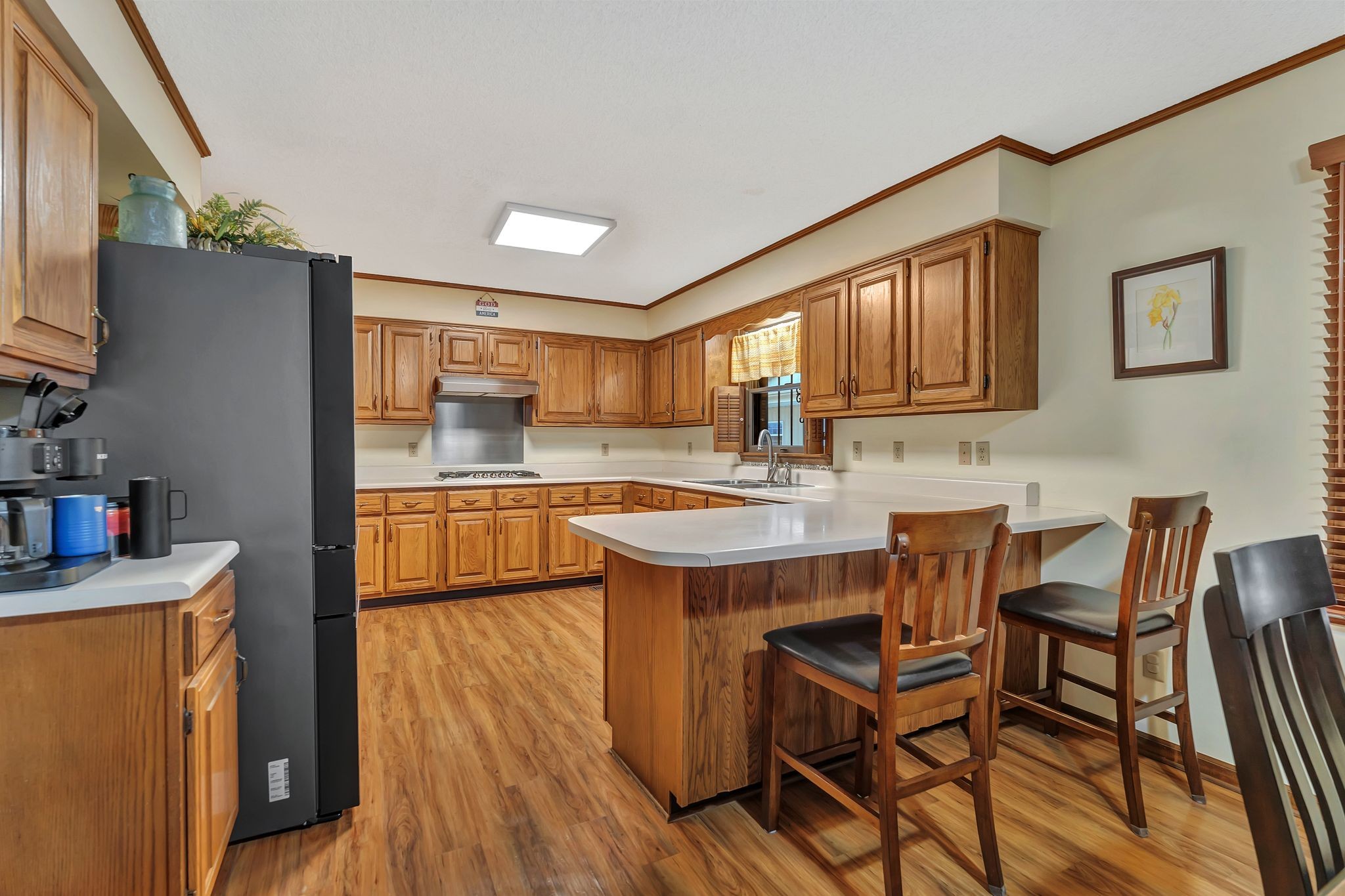 1210 Hills Chapel Road Manchester, TN 37355 - Photo 13 of 33 a kitchen with kitchen island granite countertop wooden floors and wooden cabinets