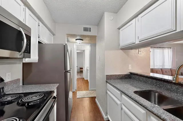 a kitchen with stainless steel appliances granite countertop a refrigerator and a stove
